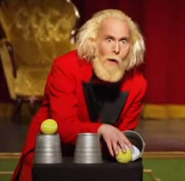 Magician John-Henry performing a cups and balls routine.