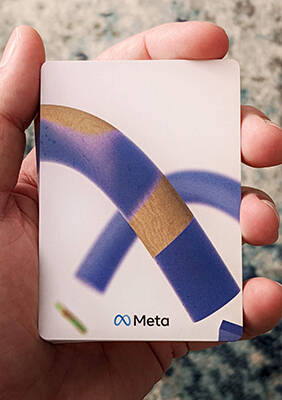 Hand holding the Meta deck showing the back design.