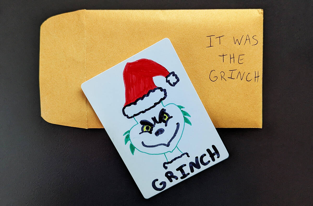 A brown envelope with "IT WAS THE GRINCH" written on it.