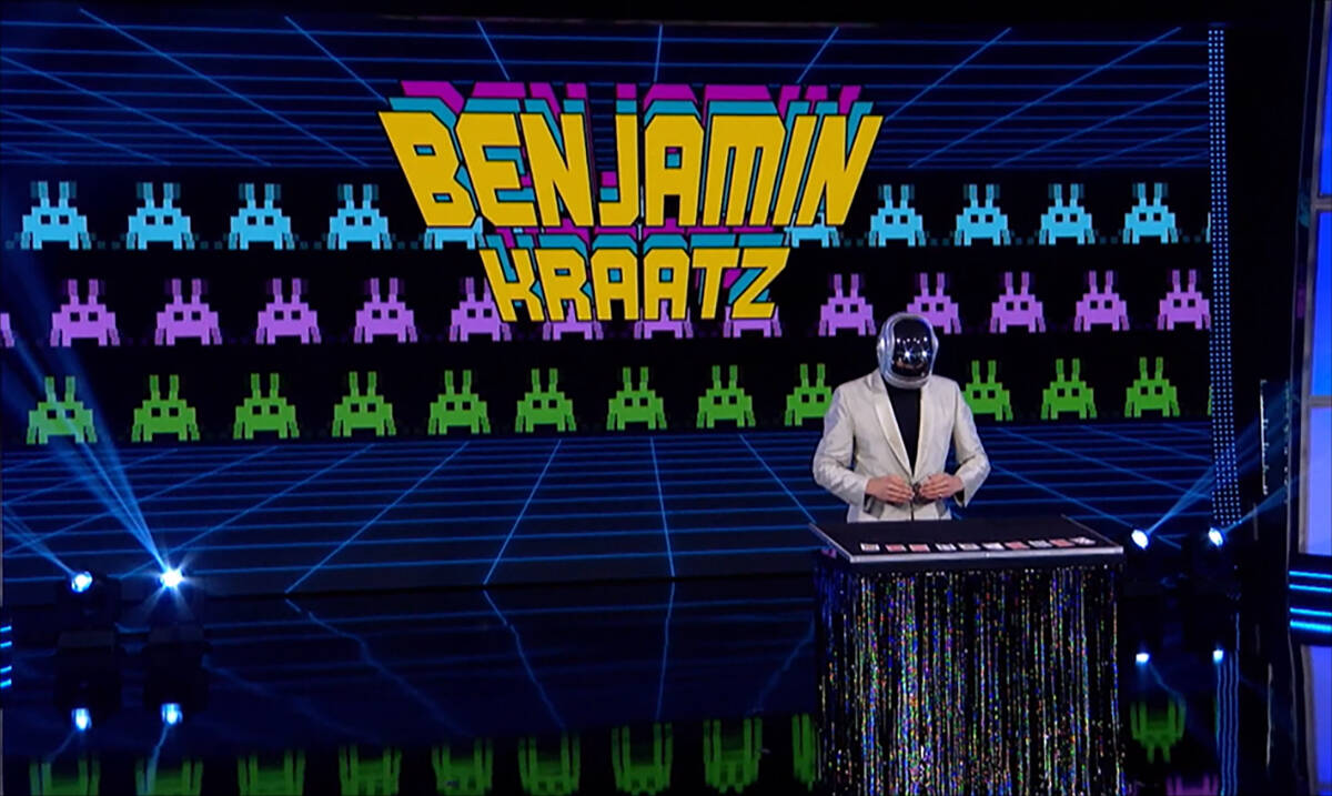 Ben Kraatz in a robot costume performing a card magic trick.