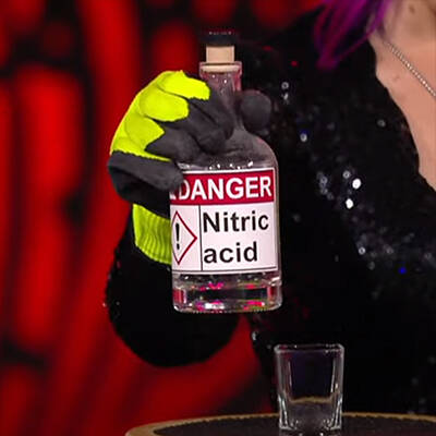 Paige Thompson holding a prop bottle of nitric acid.